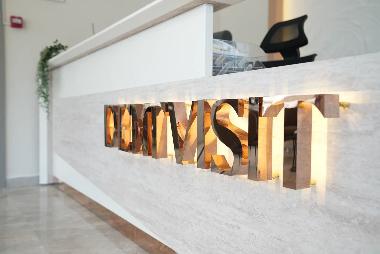 DentVisit — resepsiyon bankosunda aydınlatmalı logo