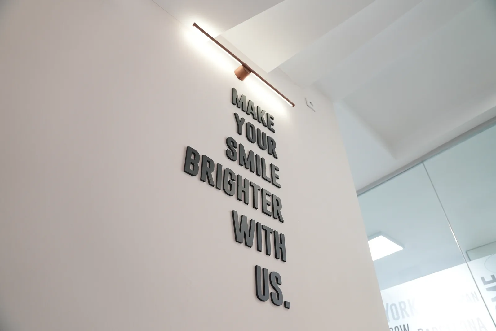 DentVisit — "Make your smile brighter with us" duvar yazısı